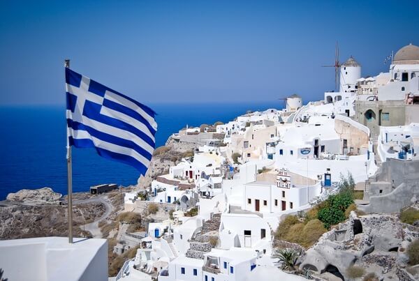 Grécka vlajka v pozadí s mestečkom 