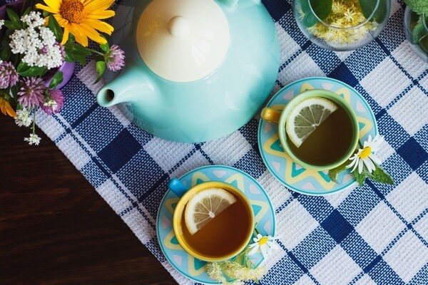 Čajník a šálky s čajom s kvetinovou dekoráciou
